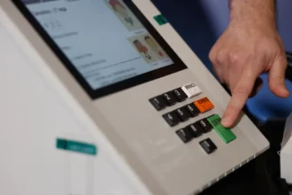 leitor vota em urna eletrônica durante as eleições.
